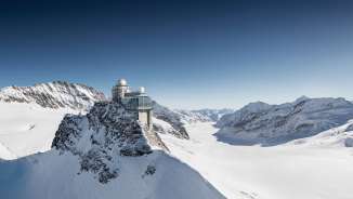 Luftaufnahme des Jungfraujoch im Winter. Im Hintergrund ist neben dem Bergpanorama der Aletschgletscher zu sehen.